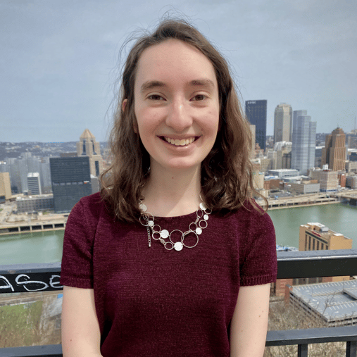 Heather Dillman smiling with the Pittsburgh skyline in the background