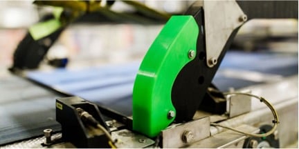 A neon green 3D printed replacement part for one of Heineken's manufacturing equipment